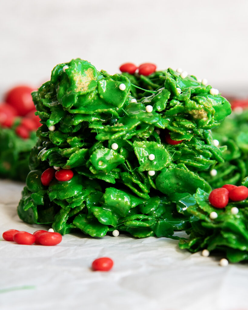 A stack of three cornflake wreaths topped with red hot candies.