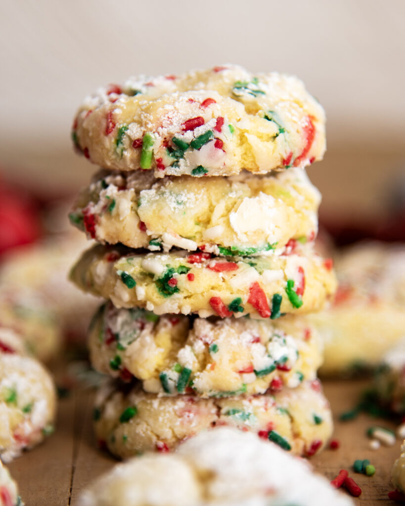 A pile of Ooey Gooey Christmas Butter Cookies loaded with red, white, and green Christmas sprinkles.