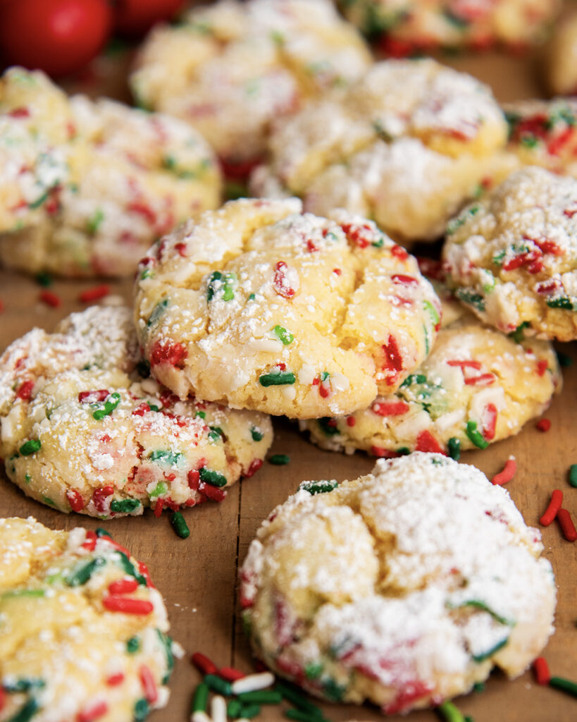 A pile of Ooey Gooey Christmas Butter Cookies loaded with red, white, and green Christmas sprinkles.