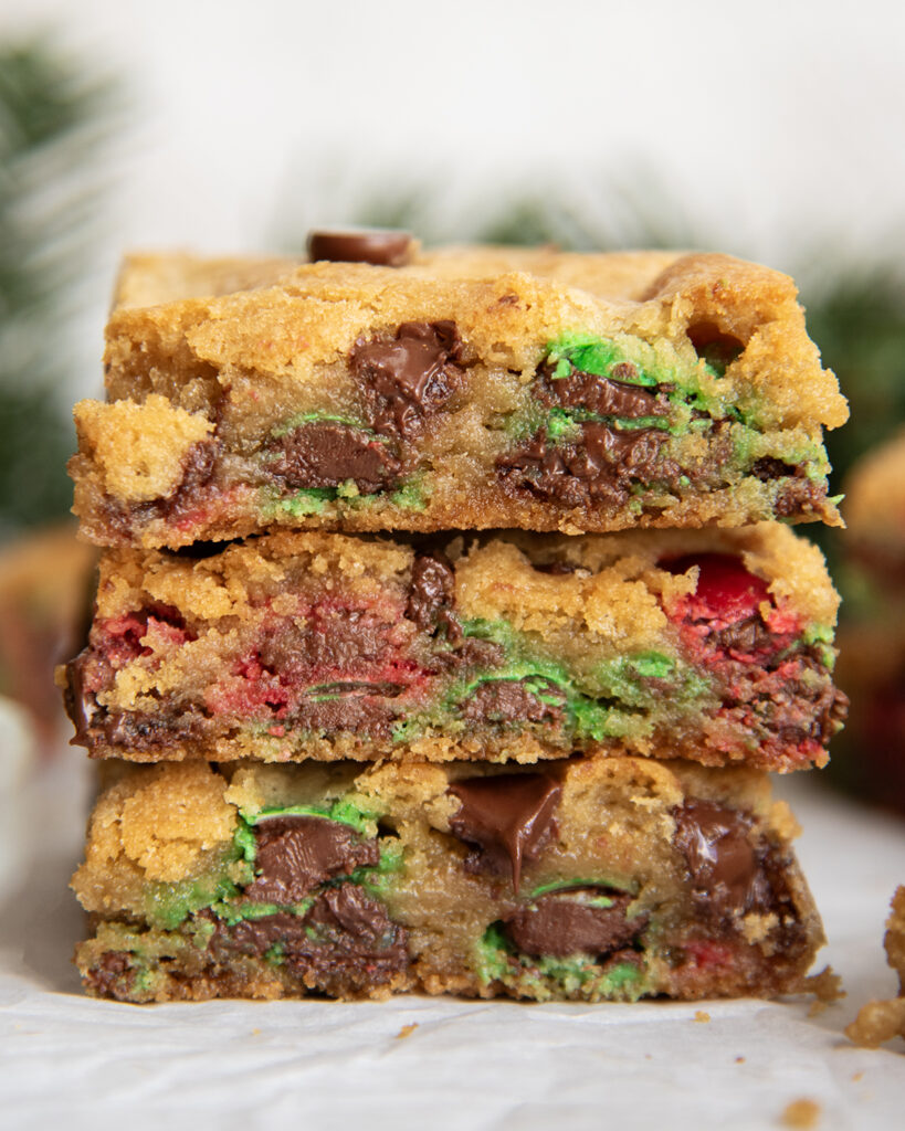 A stack of three pieces of Christmas M&M Cookie bars.