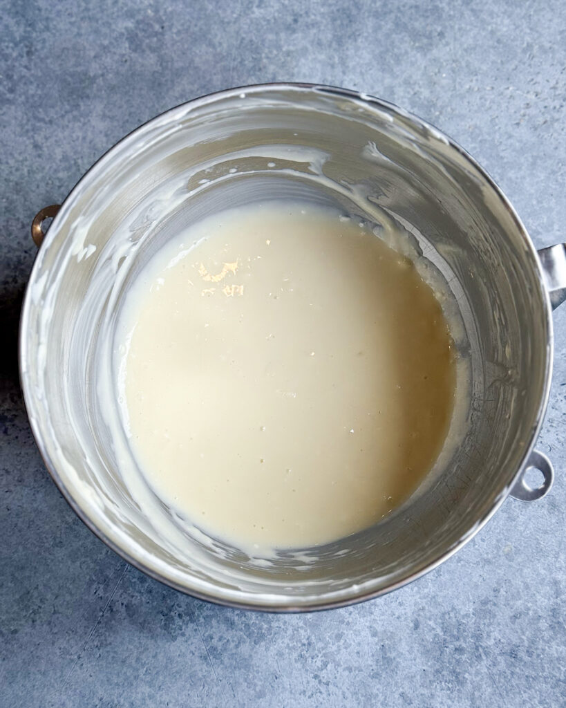 Cheesecake filling in a metal mixing bowl.