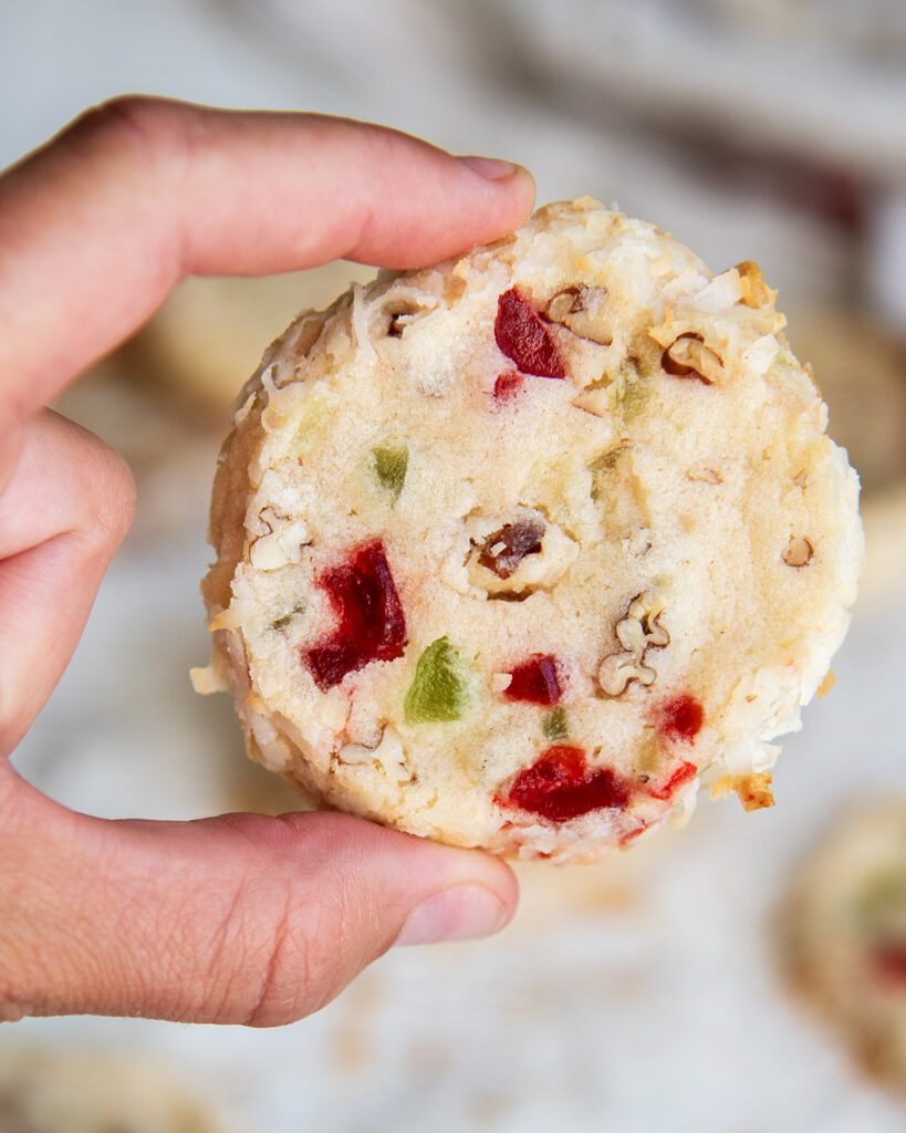 A hand holding a santa's whiskers cookie.