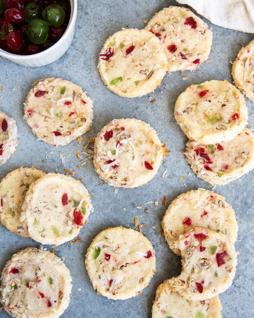 An above view of santa's whiskers cookies filled with red and green cherry pieces.