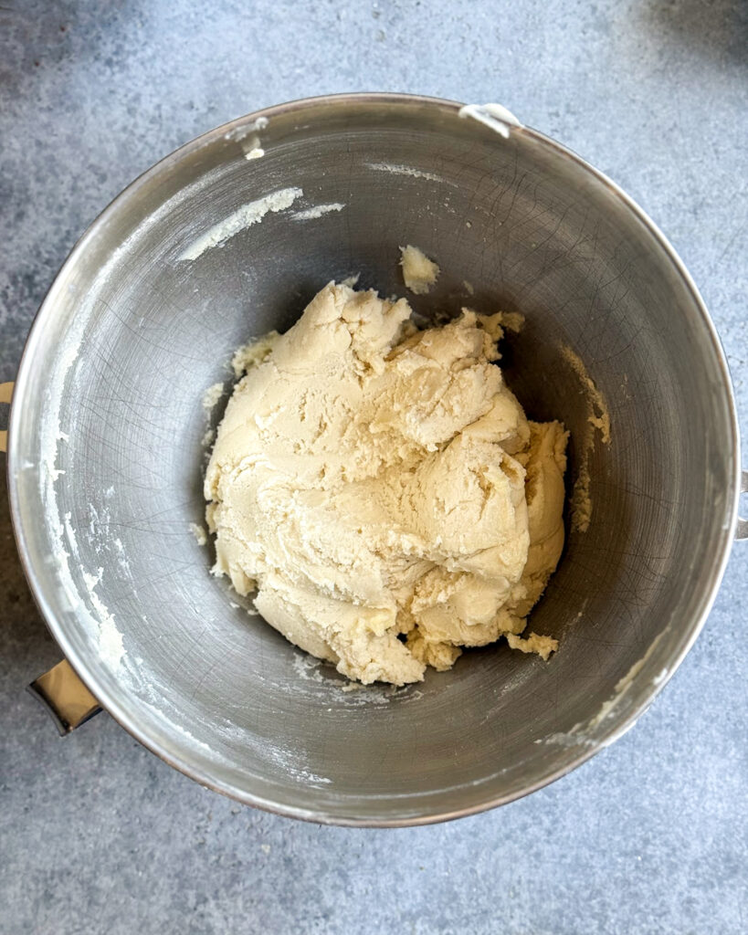 Shortbread cookie dough in a metal mixing bowl.