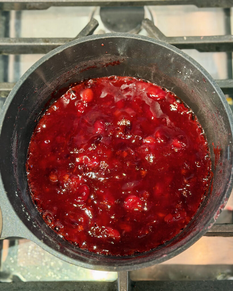 Cranbery sauce cooking in a pot.