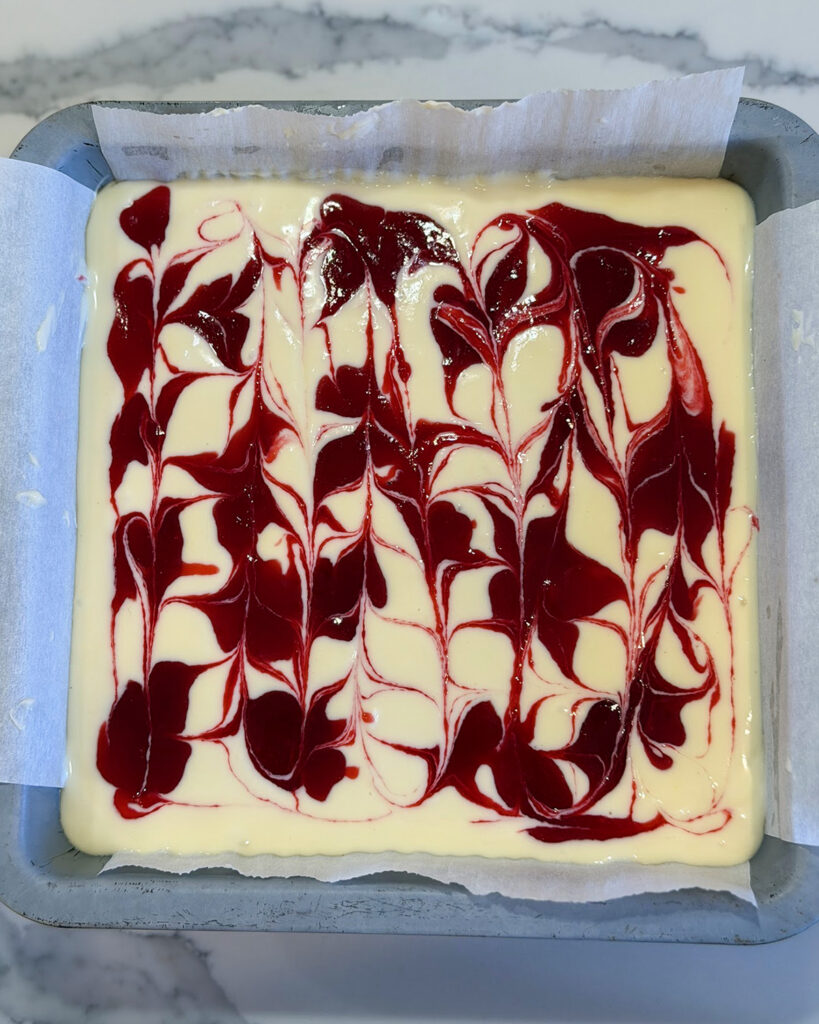 Cranberry sauce swirled into an unbaked cheesecake.