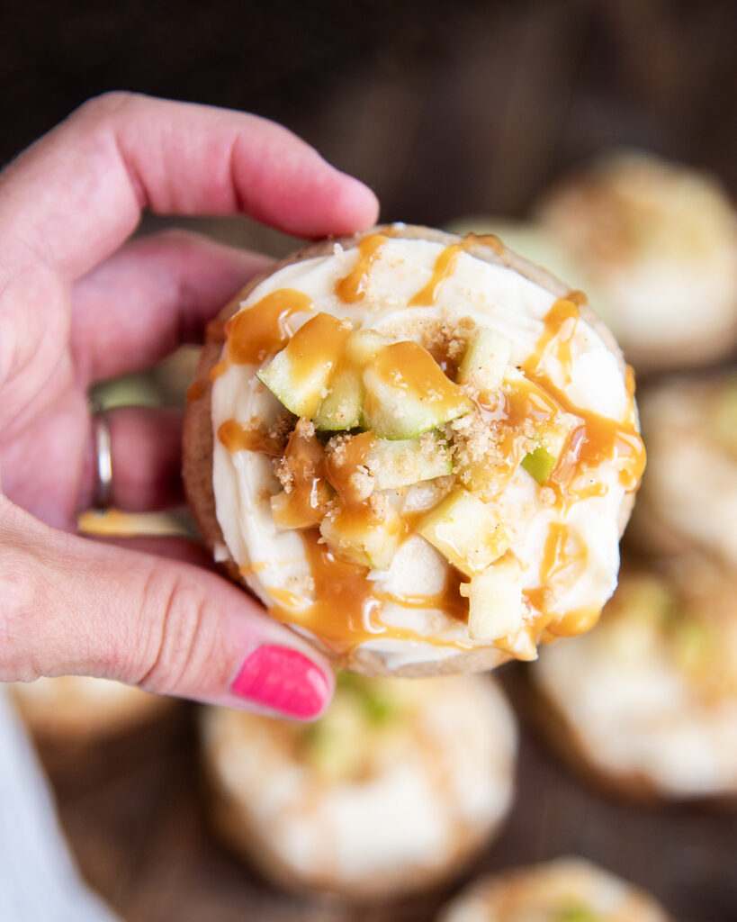 A hand holding a caramel apple cookie, that is a homemade version of crumbl.