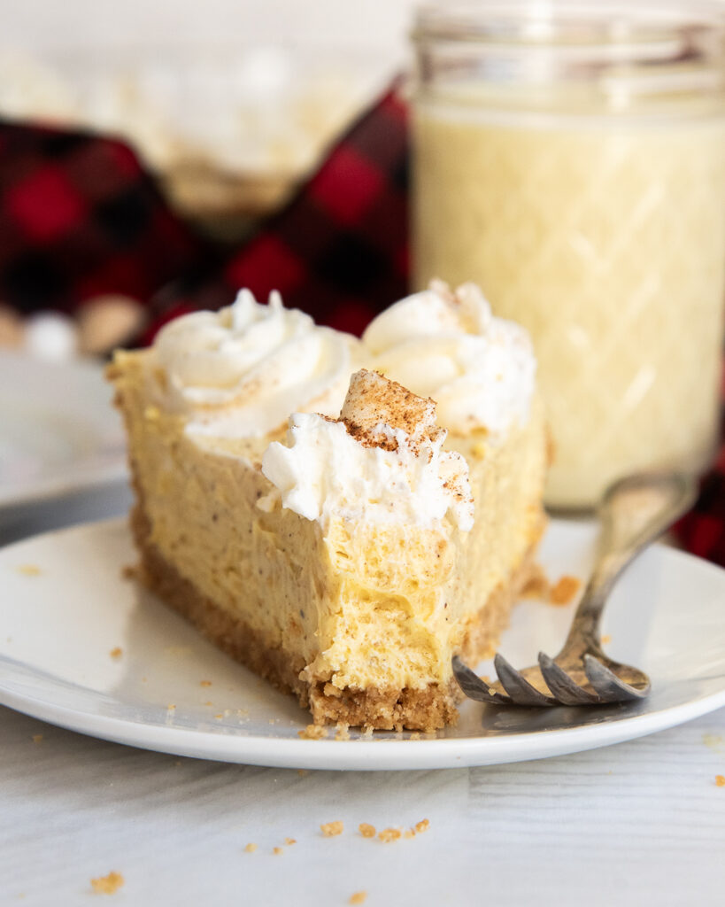 A slice of eggnog pie on a plate, with one bite taken off the front.