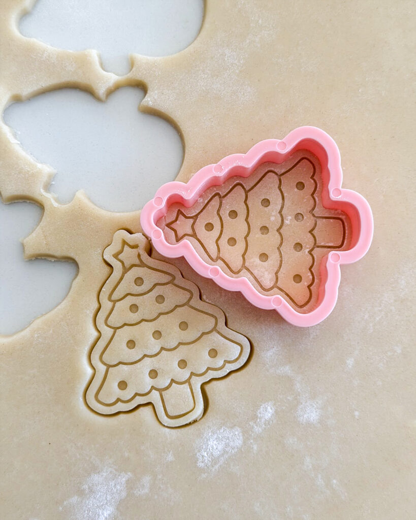 Cut out shortbread cookies, shaped like christmas trees.