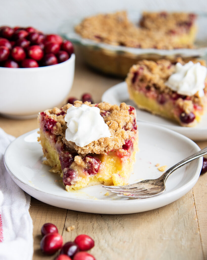 A slice of cranberry custard pie with a forkful removed from the slice. 