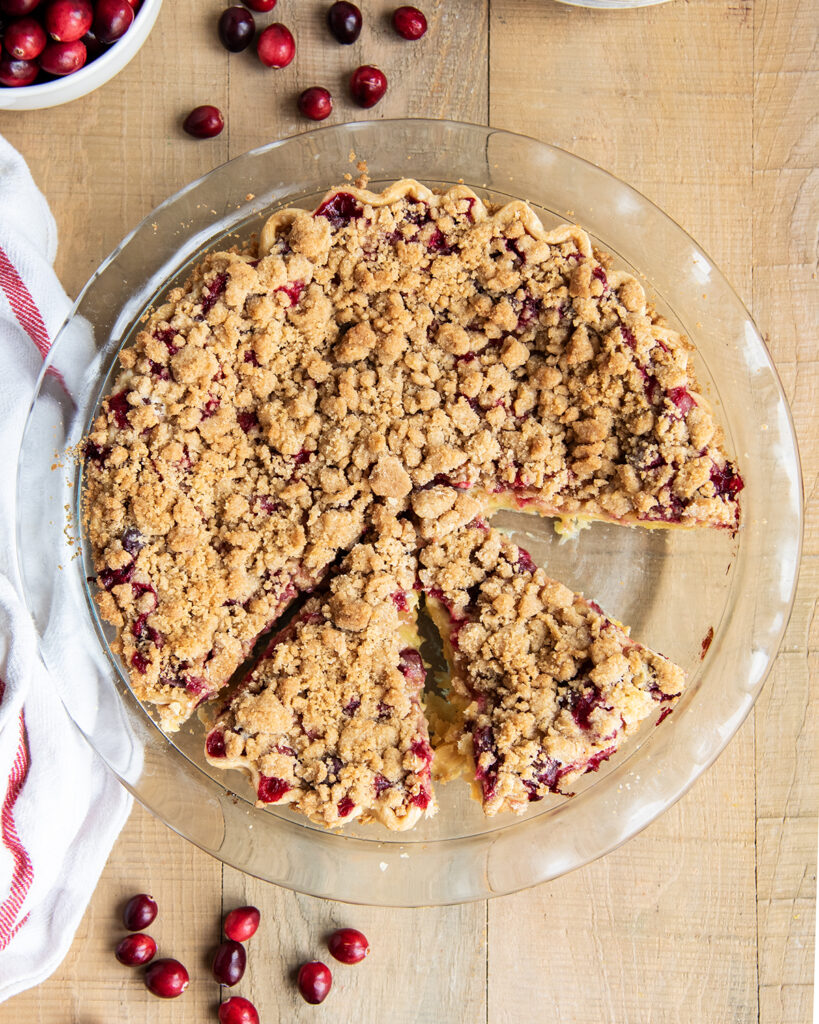 An above view of a cranberry pie with crumb topping in a glass pie plate.