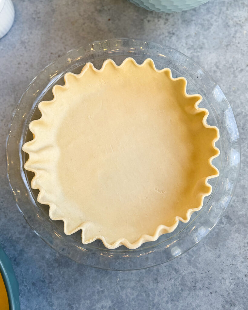 An unbaked pie crust in a glass pie plate.