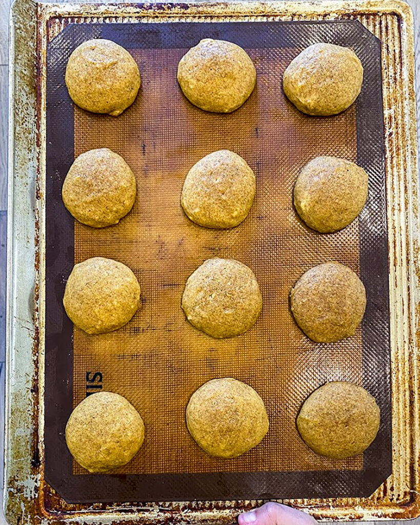 Baked whoopie pies on a cookie sheet.