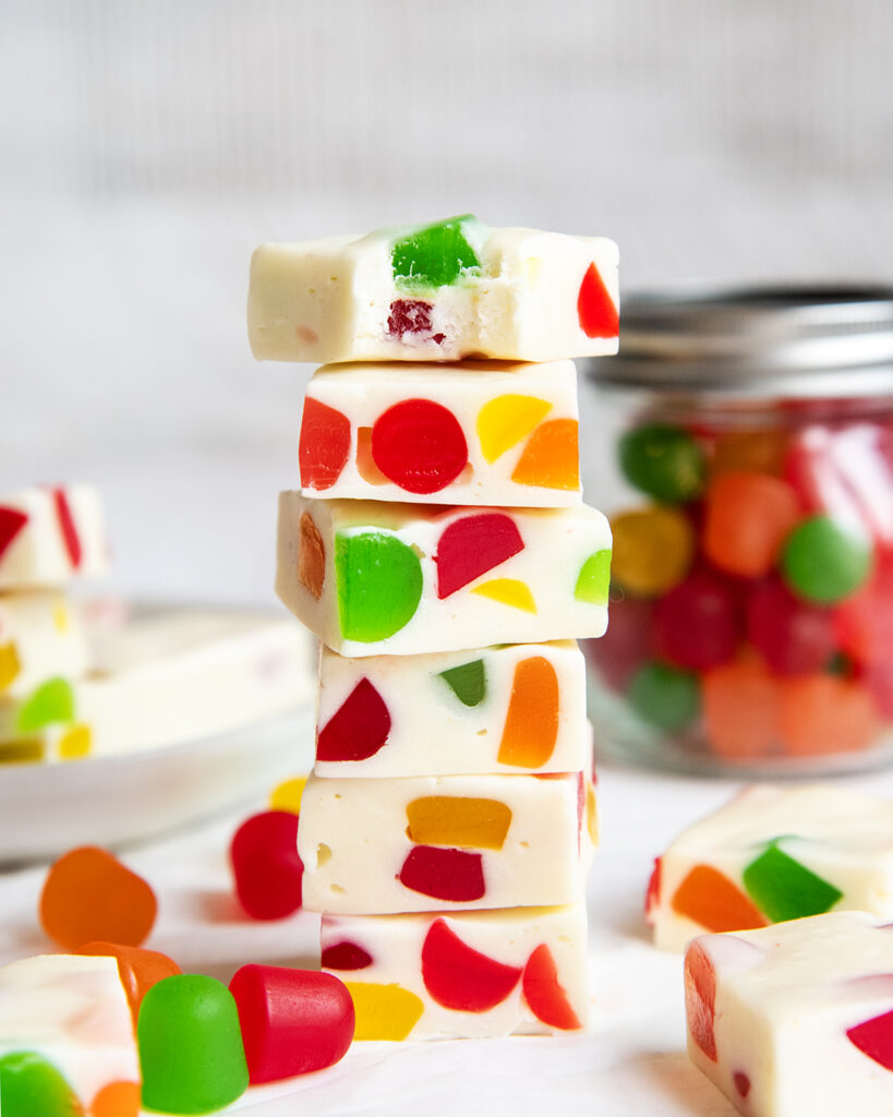 A stack of several pieces of homemade gumdrop nougat candy and the top candy has a bite out of it.