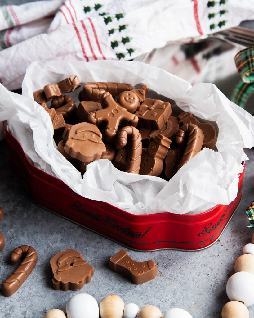 An above view of a christmas tin loaded with peanut butter meltway chocolate candies.
