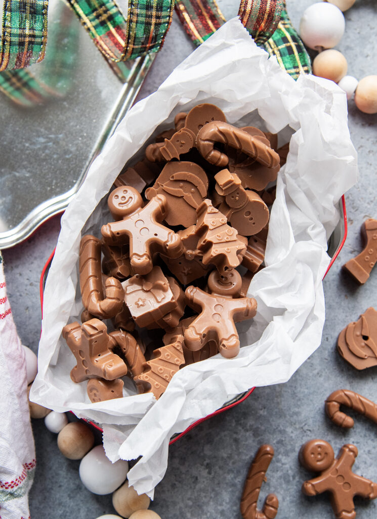 An above view of a christmas tin loaded with peanut butter meltway chocolate candies.