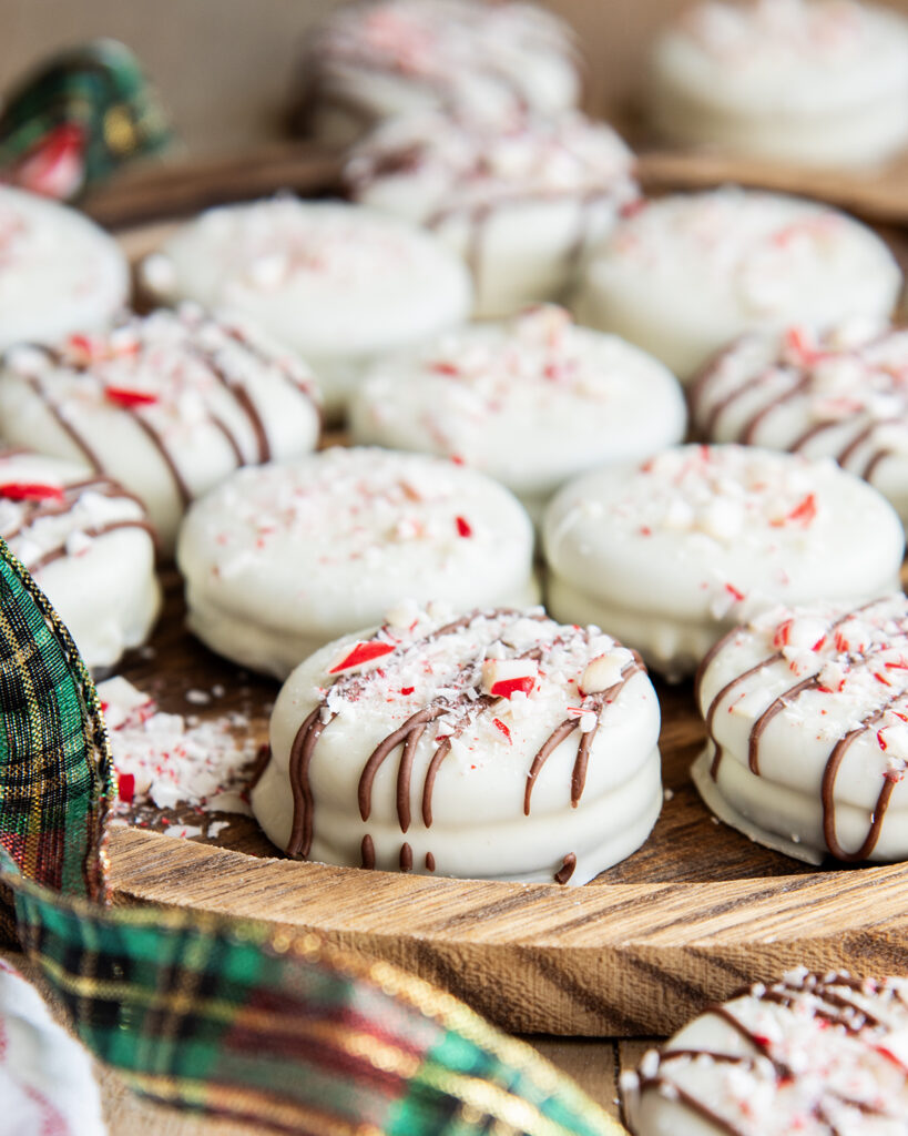 A layer of white chocolate peppermint Oreos on a wooden board.