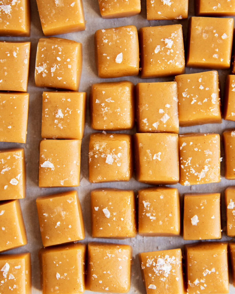 An above view of apple cider caramels topped with flakey sea salt.