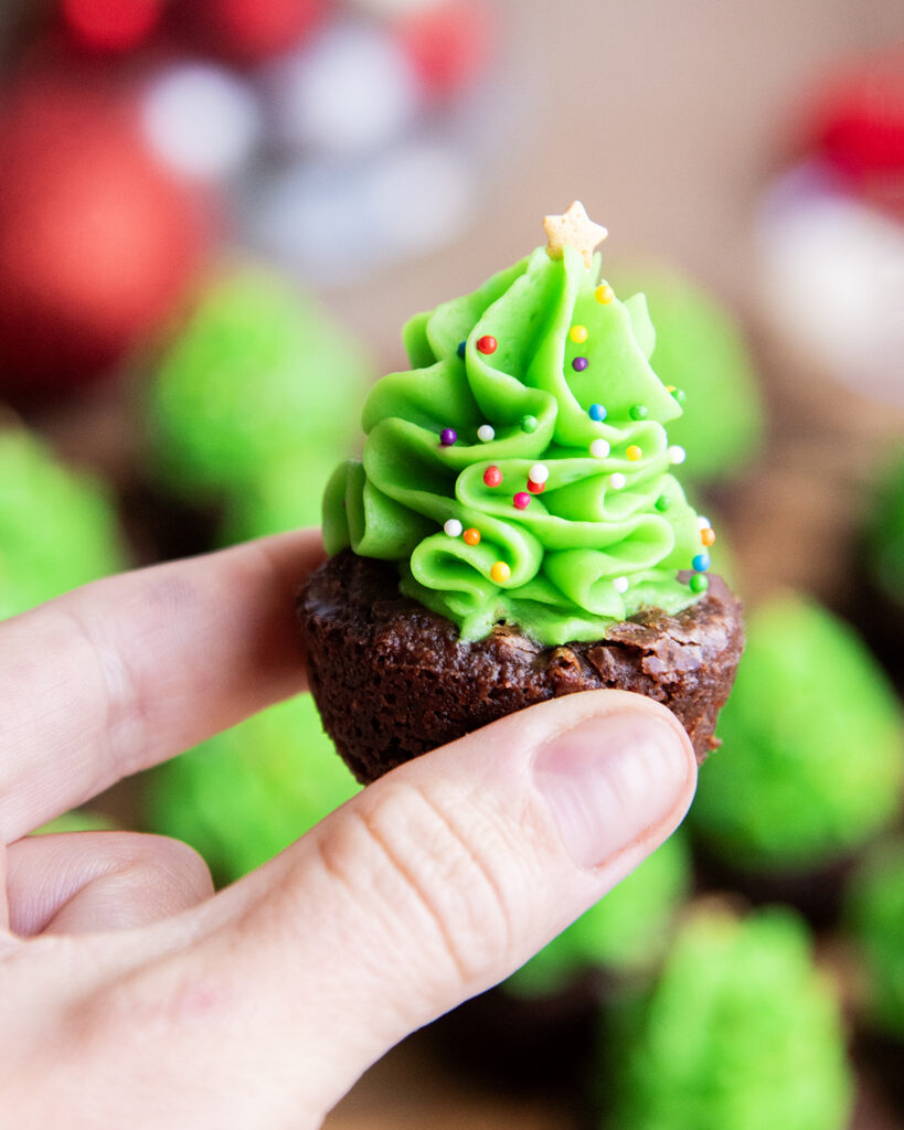 A hand holding a Christmas Tree Brownie Bite