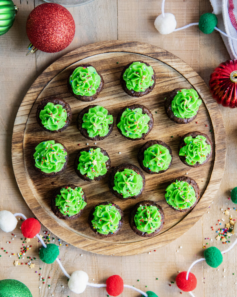 An above view of Christmas Tree Brownie Bites on a wooden tray.