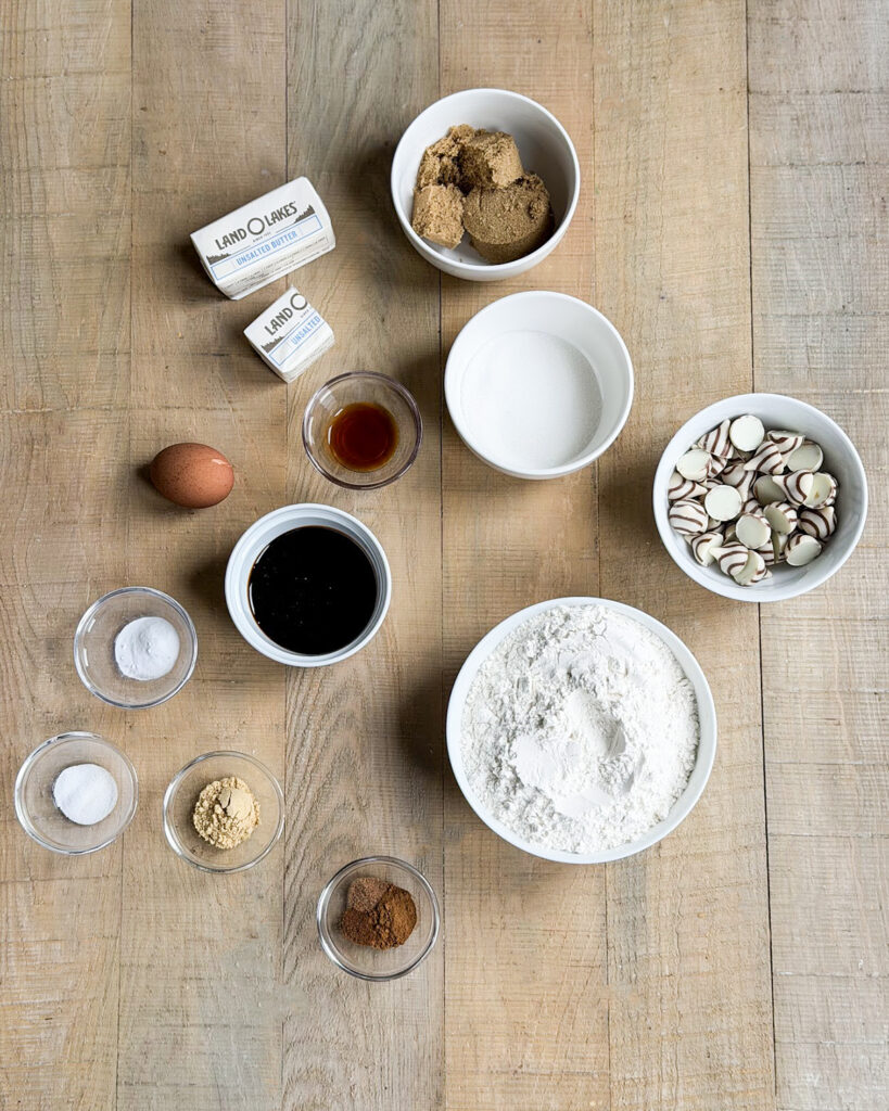 Small bowls of the ingredients needed to make ginger blossom cookies, like brown sugar, molasses, kisses, butter, etc.