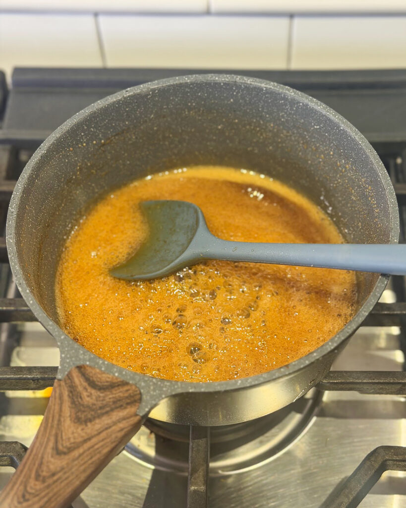 Apple cider concentrate cooking down in a pot.
