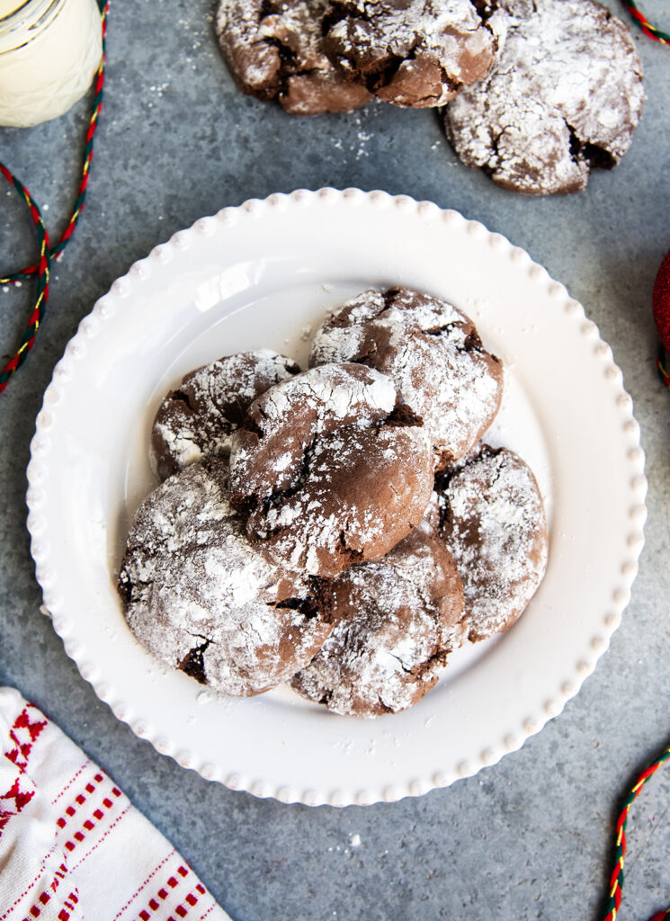 A plate of chocolate cake mix crinkle cookies in a pile.