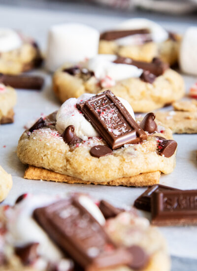 A Peppermint S'more cookie baked on half a graham cracker on a piece of parchment paper.