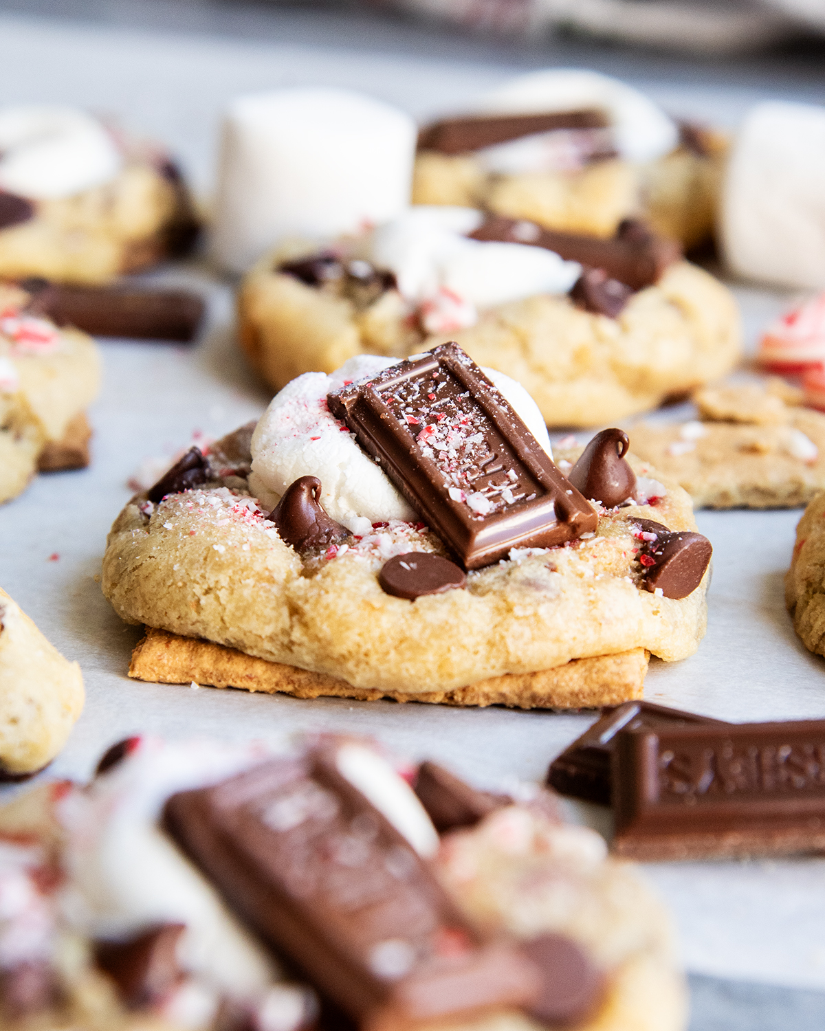 A Peppermint S'more cookie baked on half a graham cracker on a piece of parchment paper.