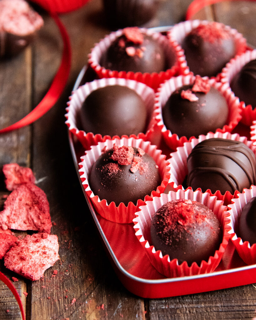 A close up of strawberry buttercream chocolates in a tin.