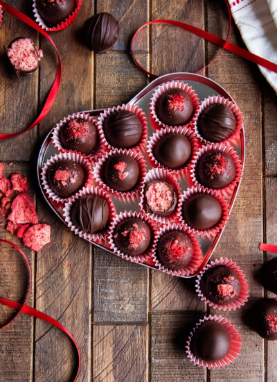 A heart shaped tin full of strawberry cream chocolates.