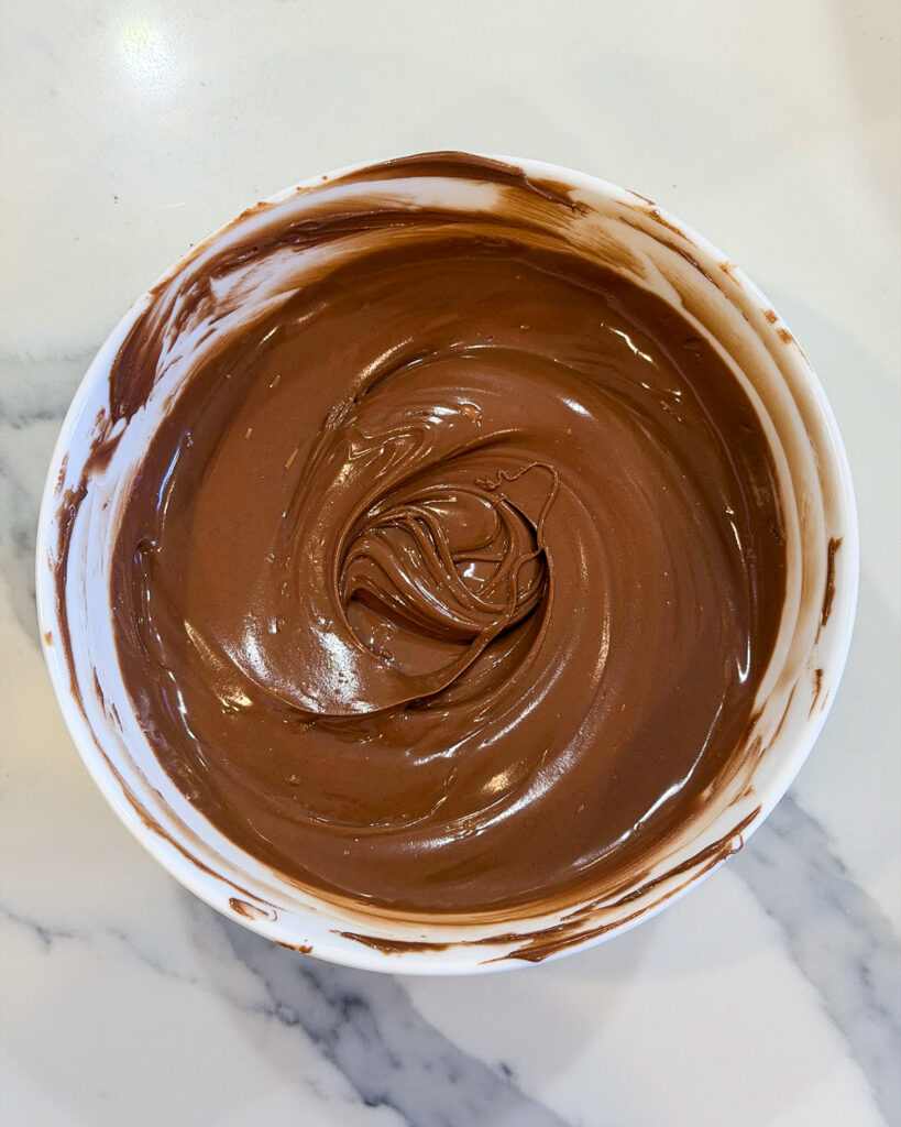 Melted chocolate in a white bowl.