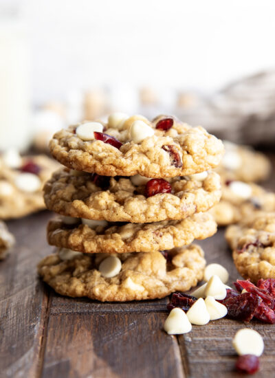 A stack of four oatmeal white chocolate and cranberry cookies.