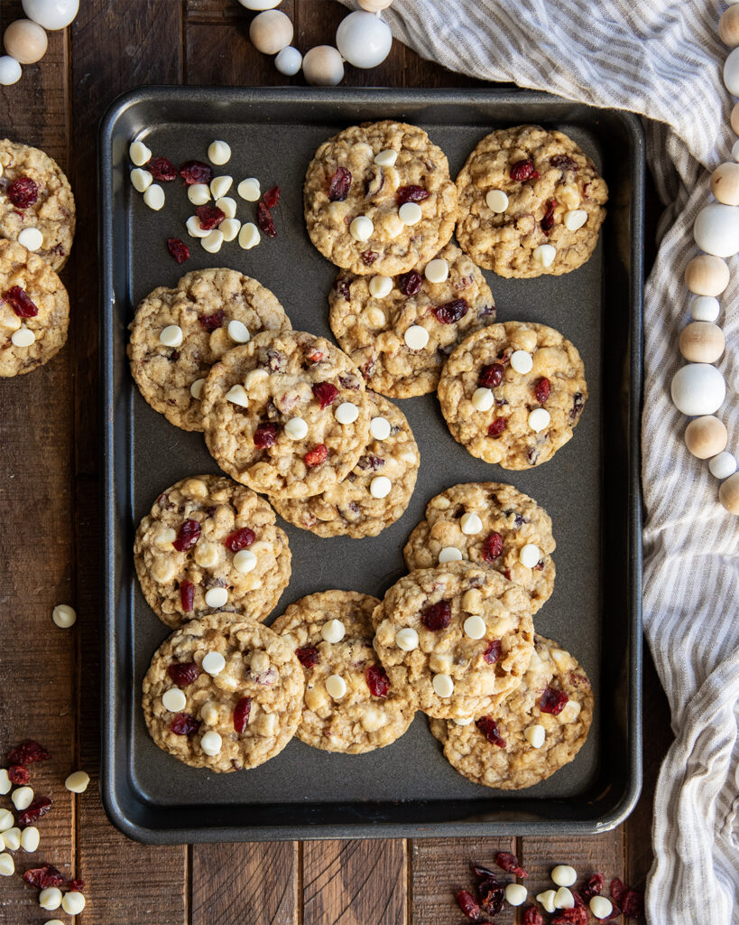 A cookie sheet with oatmeal cranberry white chocolate cookies on it.