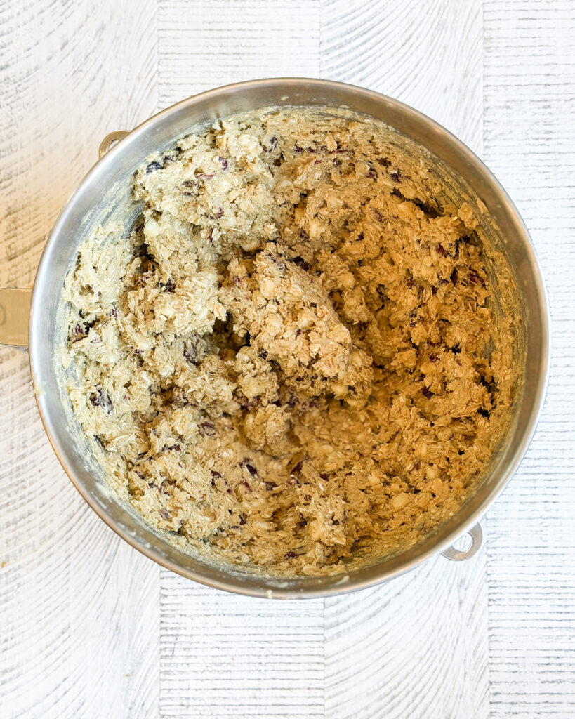 Oatmeal cranberry cookie dough in a metal mixing bowl.