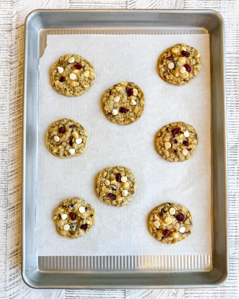 Oatmeal Cranberry White Chocolate Cookies on a parchment lined cookie sheet.