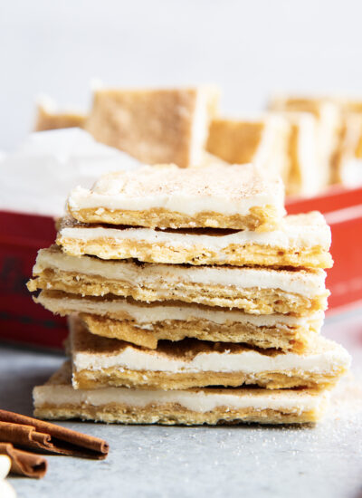 A stack of churro toffee pieces standing in a pile. It's a cracker bottom, toffee top, then cinnamon sugar white chocolate on top.