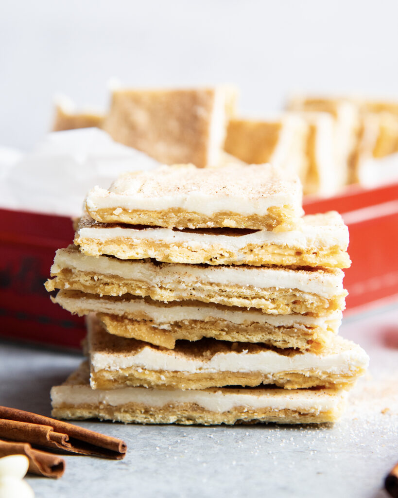 A stack of churro toffee pieces standing in a pile. It's a cracker bottom, toffee top, then cinnamon sugar white chocolate on top.