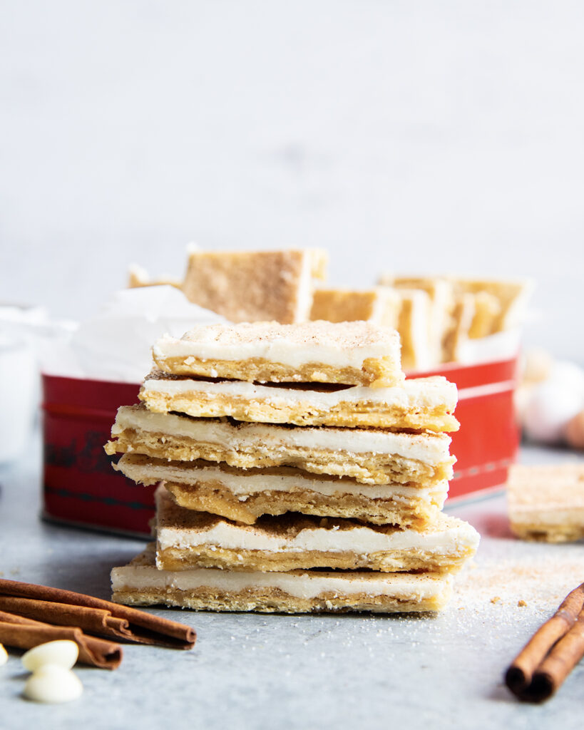 A stack of churro toffee pieces standing in a pile. It's a cracker bottom, toffee top, then cinnamon sugar white chocolate on top.