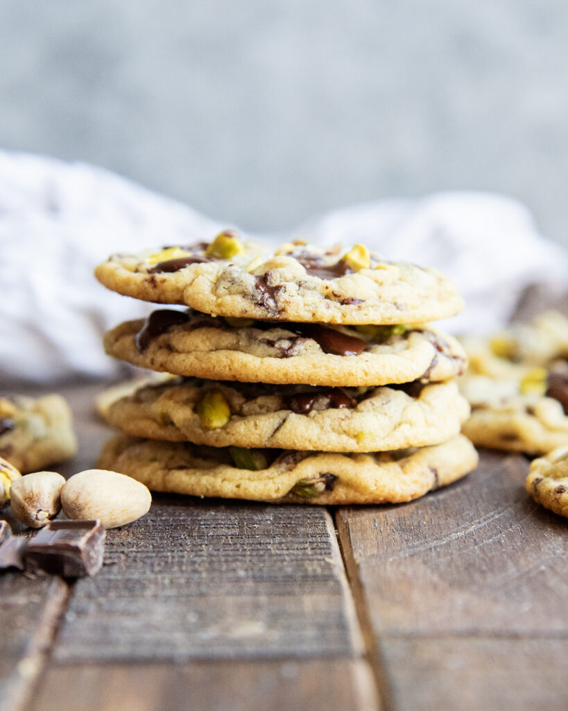 A stack of four pistachio chocolate chip cookies.