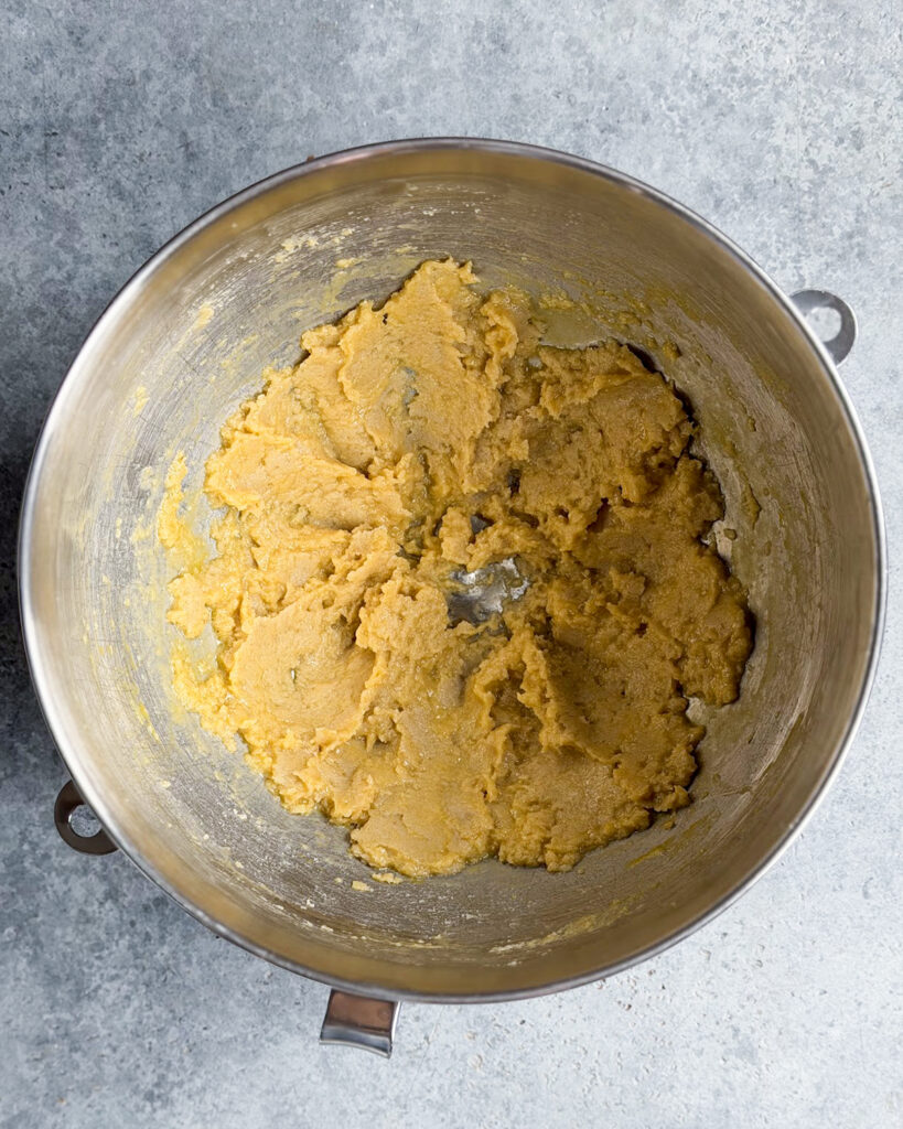 Creamed butter and sugars in a metal bowl.