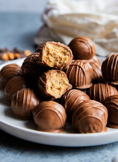 A plate of scotcheroo balls, and two are opened showing the rice crispy peanut butter center.