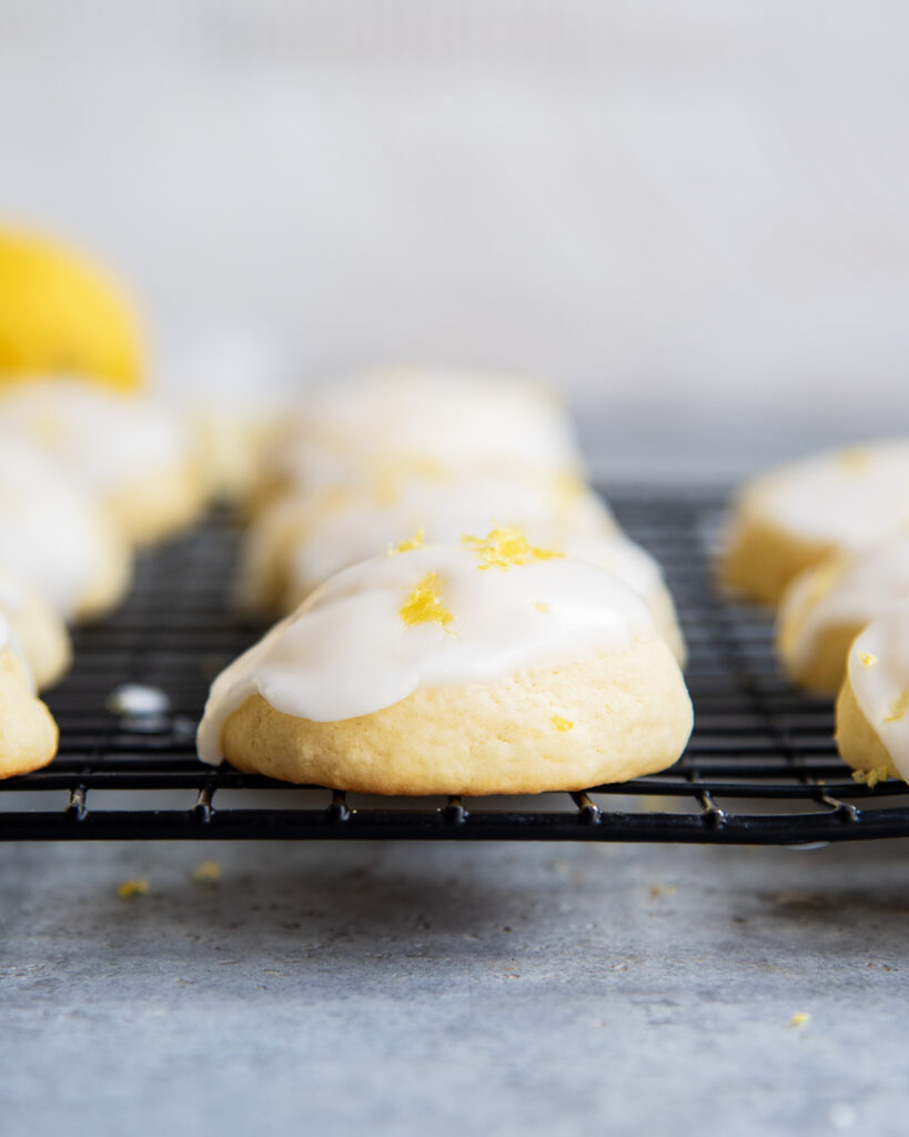 A row of lemon ricotta cookies on a wire cooling rack.