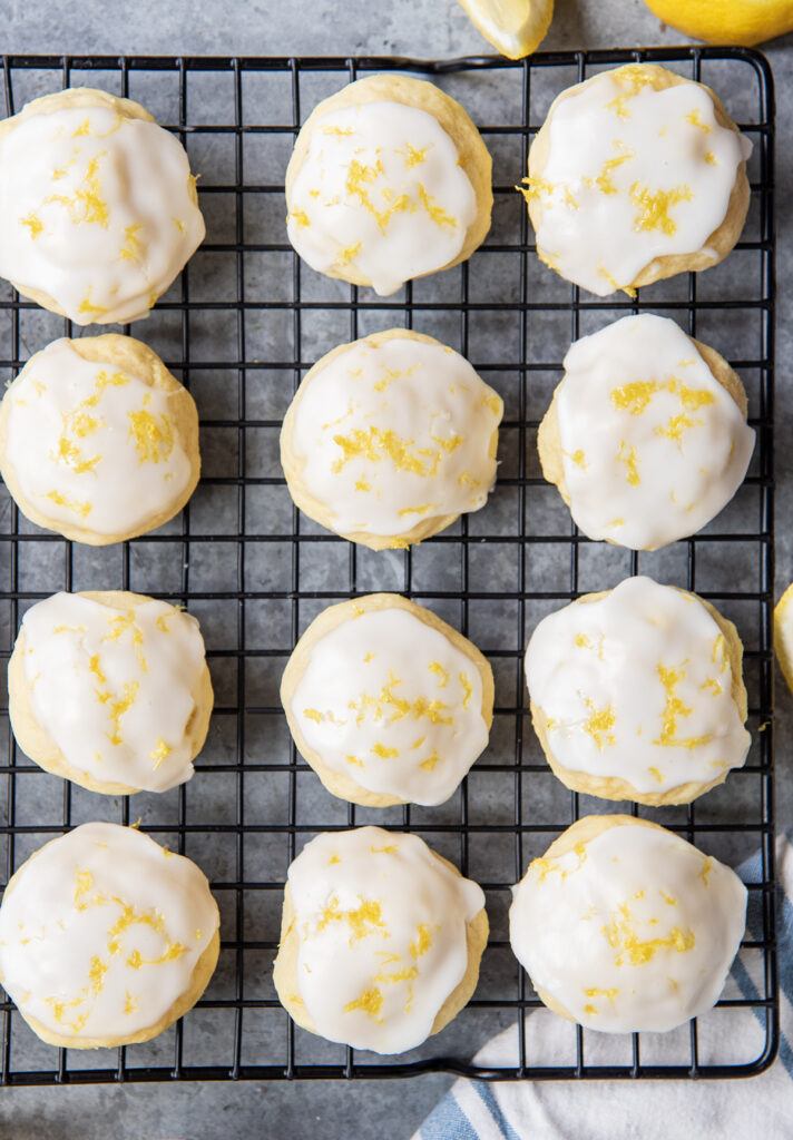 An above view of glazed lemon ricotta cookies on a wire cooling rack.