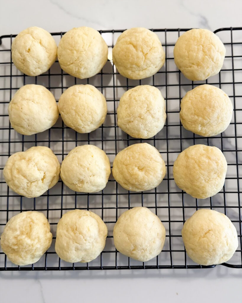 Unglazed ricotta cookies on a cookie sheet.