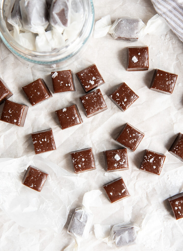 An above view of chewy chocolate flavored caramels with flakey salt on top.