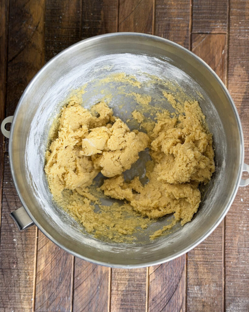 Sugar cookie dough in a metal mixing bowl.