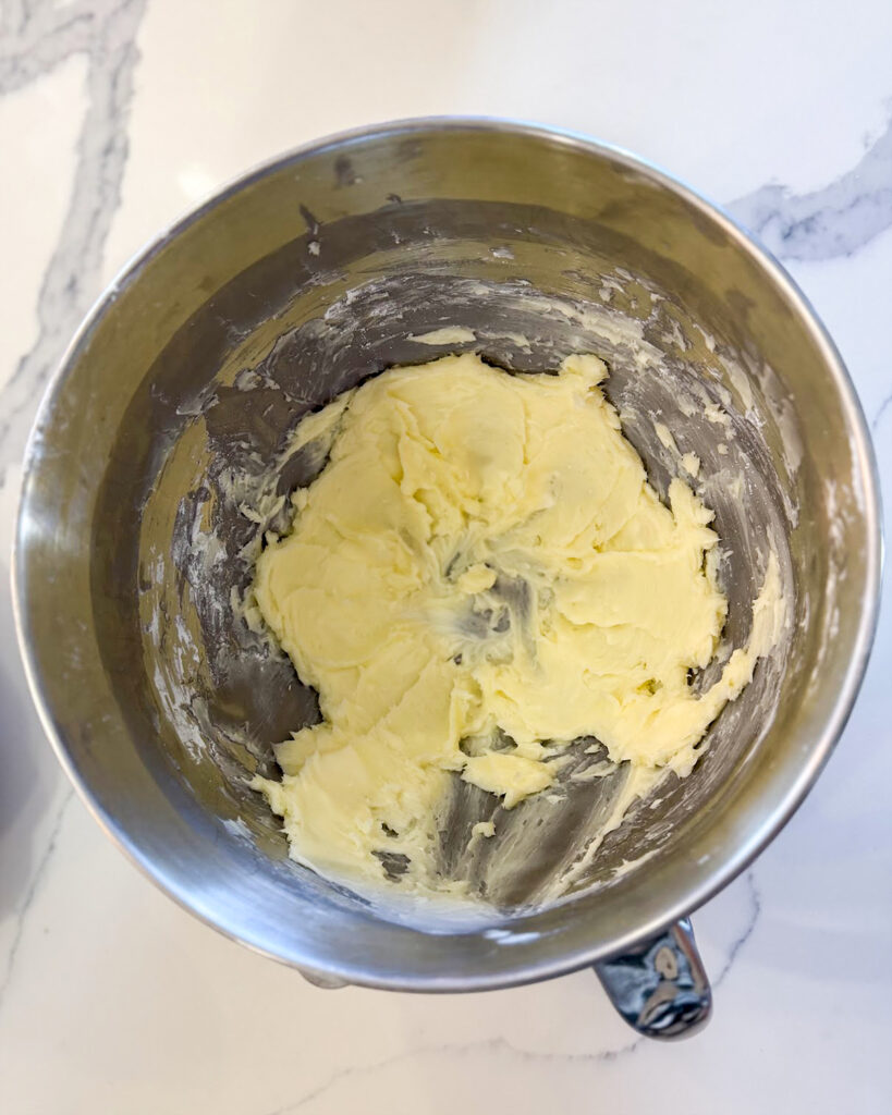 A bowl of creamed butter and powdered sugar. 