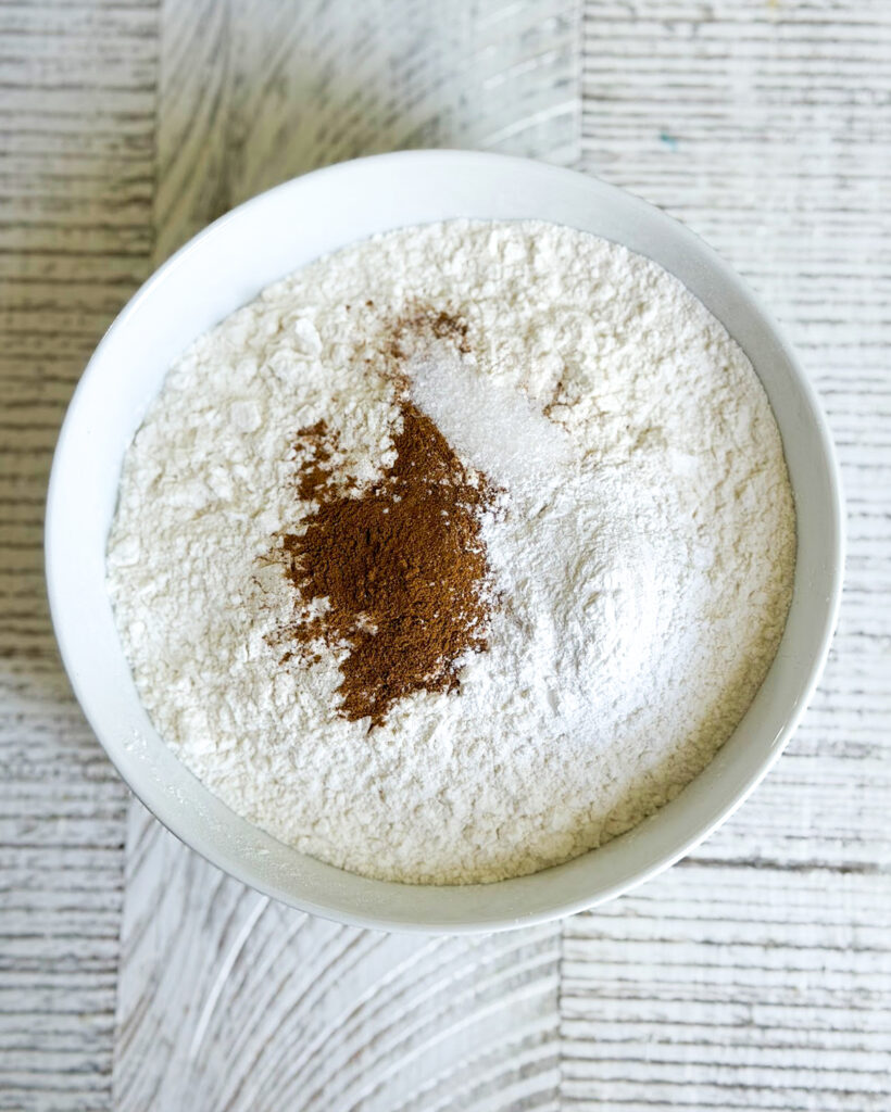 Flour topped with salt and cinnamon in a small bowl.