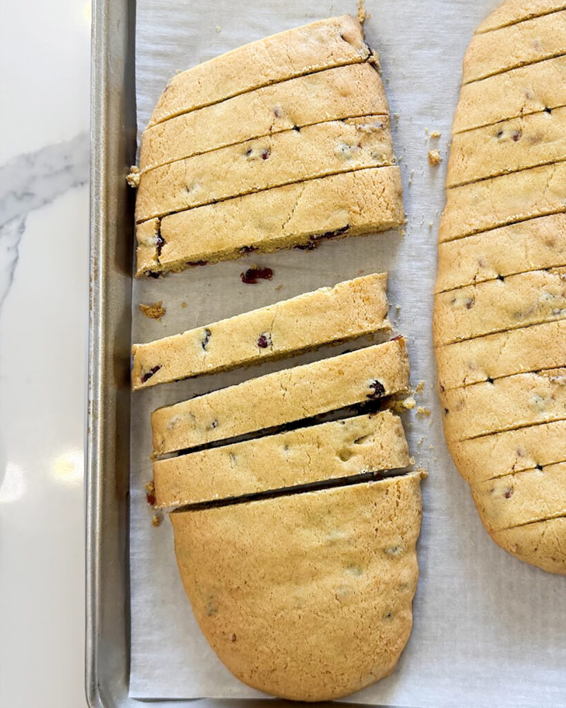 Sliced biscotti on a baking pan.